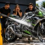 A Kawasaki de alta cilindrada totalmente coberta por espuma branca sendo lavada por uma lavadora de alta pressão vender 1800